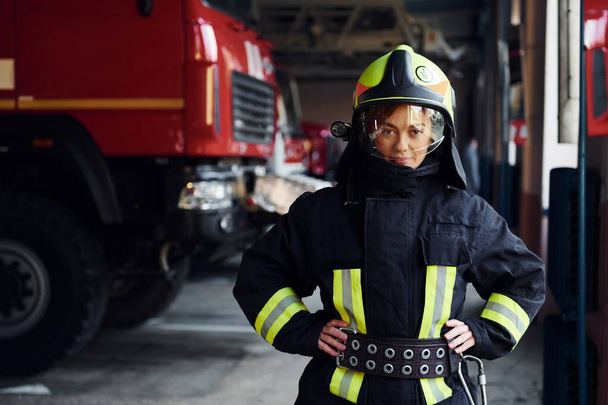 Female firefighter in protective uniform standing near truck. - Fotoğraf, Görsel