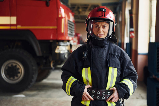 Female firefighter in protective uniform standing near truck. - Foto, Imagen