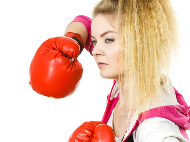 Sporty woman wearing red boxing gloves, fighting. Studio shot on white background. - Fotografie, Obrázek