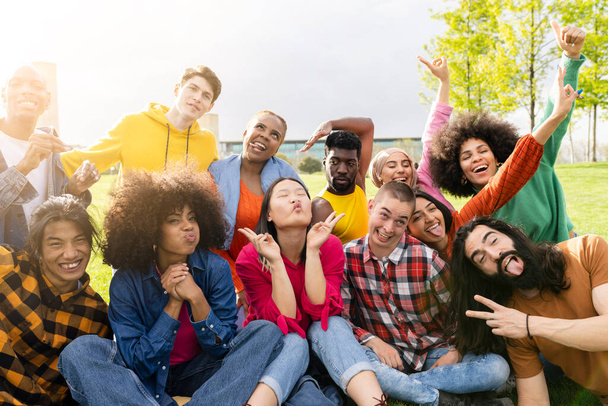 Diverse young people having fun outdoors laughing together making funny faces joking for selfie. Multiracial group of diverse sexual orientations - focus on Asian women -. - 写真・画像