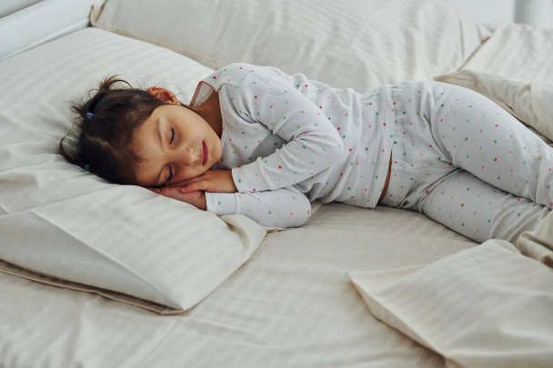 Little girl sleeps. Interior and design of beautiful modern bedroom at daytime. - Фото, зображення