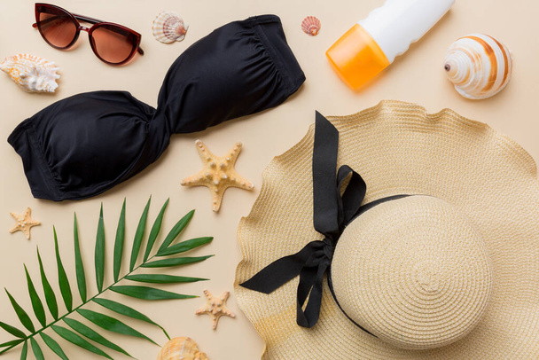Woman swimwear and beach accessories flat lay top view on colored background Summer travel concept. bikini swimsuit, straw hat and seasheels. Copy space Top view. - Foto, Imagem