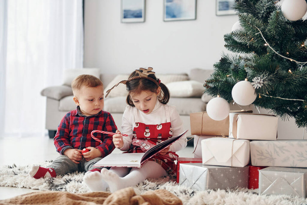 Little brother with her daughter celebrates New year and christmas at home. - Fotoğraf, Görsel