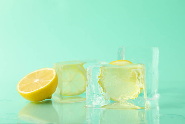 Ледяные формы с лимоном на фоне мяты - Фото, изображение