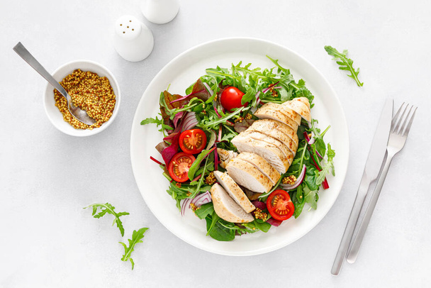 Chicken meat breast and fresh vegetable salad of tomato, onion and salad mix. Healthy and detox food. Ketogenic diet. Top view - Fotografie, Obrázek