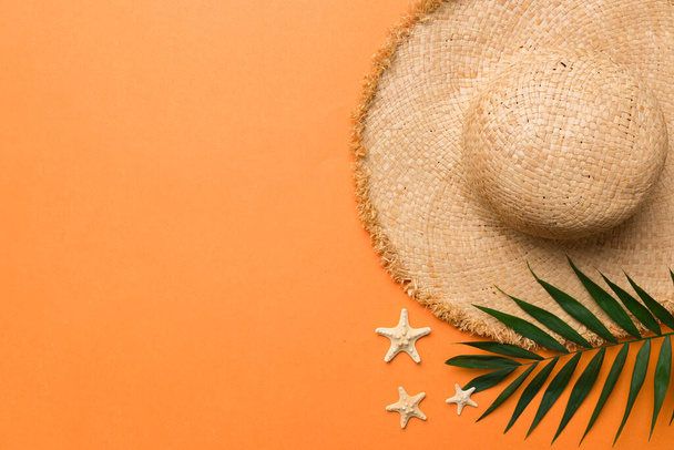 Summer holidays. Summer concept with straw hat and tropical leaf. Flat lay, top view, copy space. - Photo, image