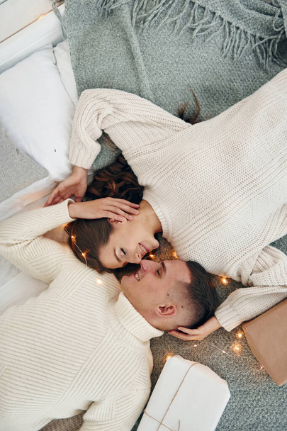 Top view of young romantic couple that lying down and celebrates New year together indoors. - Φωτογραφία, εικόνα