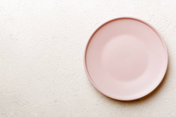 Top view of empty pink plate on cement background. Empty space for your design. - Foto, afbeelding