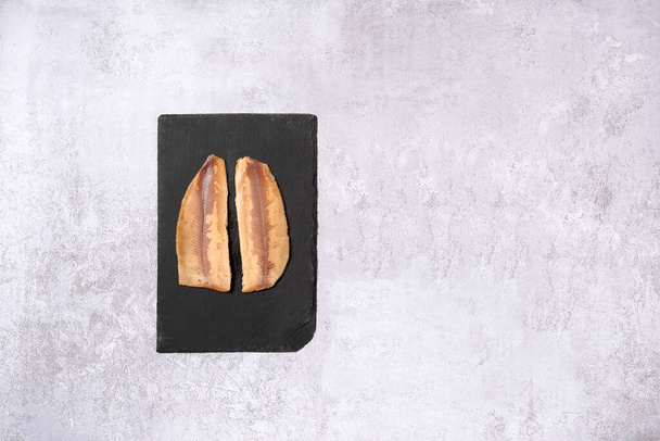 Two pieces of raw trout on slate on a white background - Foto, Imagen