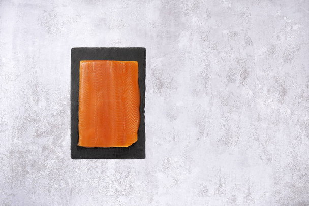 Piece of trout on slate on a white background - Fotoğraf, Görsel