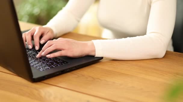 Unrecognizable hand female chatting online in social network using typing on laptop keyboard, working, writing emails, freelancer woman working on notebook at home - Footage, Video