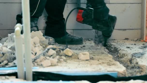 Construction and repair in a room or house. electric tools for breaking the concrete cover. The master breaks the concrete with a bumper. - Filmmaterial, Video