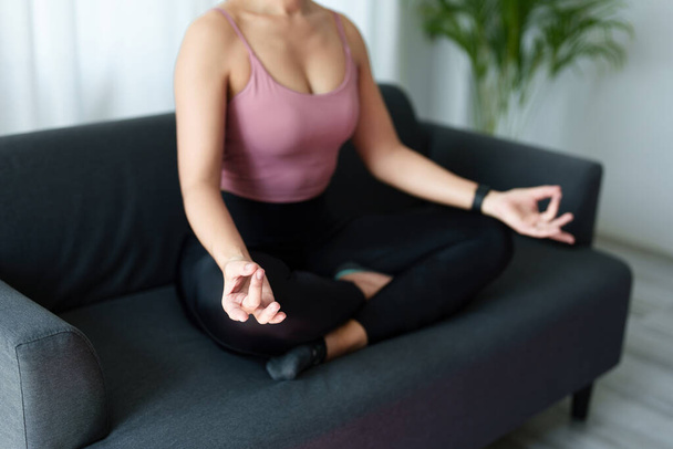 stresszoldás, izomlazítás, légzőgyakorlatok, testmozgás, meditáció, portré fiatal ázsiai nőről, aki a jóga gyakorlásával lazítja el testét az irodai munkától online oktatóanyagok nézésével. - Fotó, kép