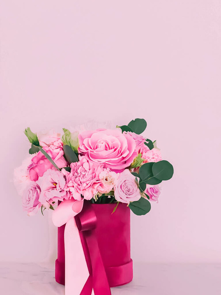 Beautiful bouquet of blooming flowers in flower box on pink background, holiday gift, luxury floral design concept - Photo, image