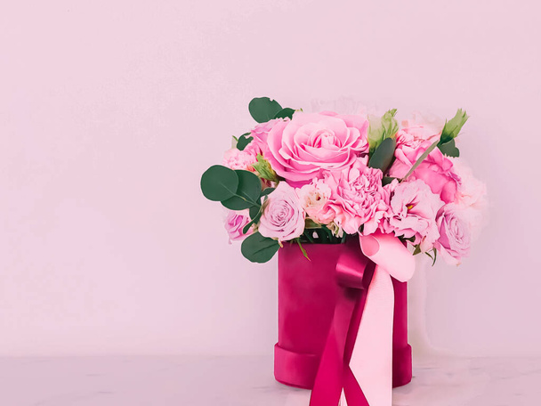 Schöner Strauß blühender Blumen in Blumenkasten auf rosa Hintergrund, Urlaubsgeschenk, Luxus-Blumendesign-Konzept - Foto, Bild