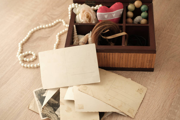 dear to heart memorabilia in an old wooden box, lock of hair, stack of retro photos, vintage photographs of 40s - 50s, concept family tree, genealogy, memories, home archive, keep as a keepsake - Zdjęcie, obraz