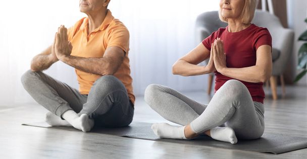Cropped of athletic senior couple meditating together at home, panorama - Zdjęcie, obraz