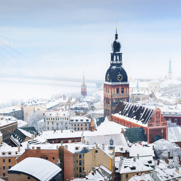 Panoramic aerial view of the Riga old town and Daugava river from St. Peter's Church in winter. Morning fog, snow-covered houses. Latvia. Landmarks, sightseeing - Photo, Image