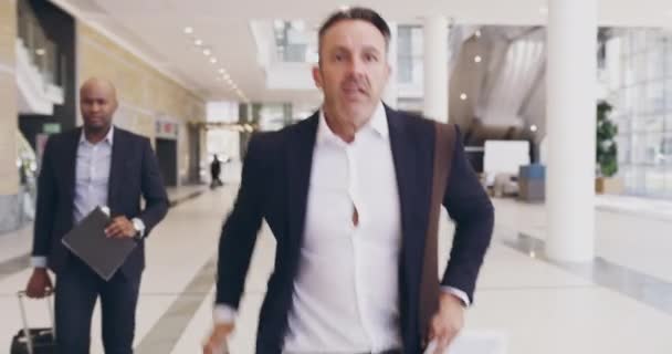 Hurrying on towards his next big opportunity. 4k video footage of a mature businessman running amongst a group of businesspeople in a convention centre. - Séquence, vidéo