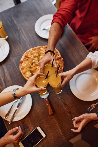 Close up view of people that taking and eating pizza indoors together. - Foto, Bild