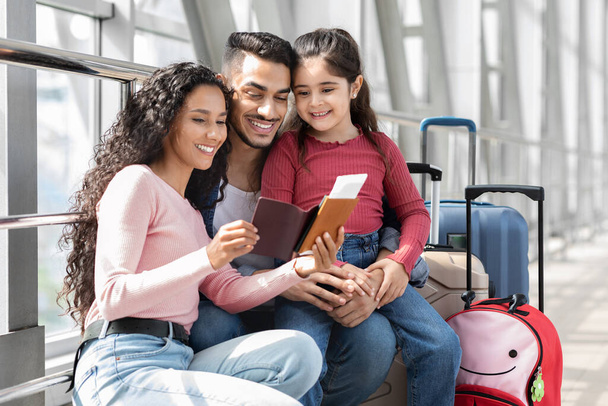 Retrato de alegre família árabe com a filha à espera de voo no aeroporto - Foto, Imagem
