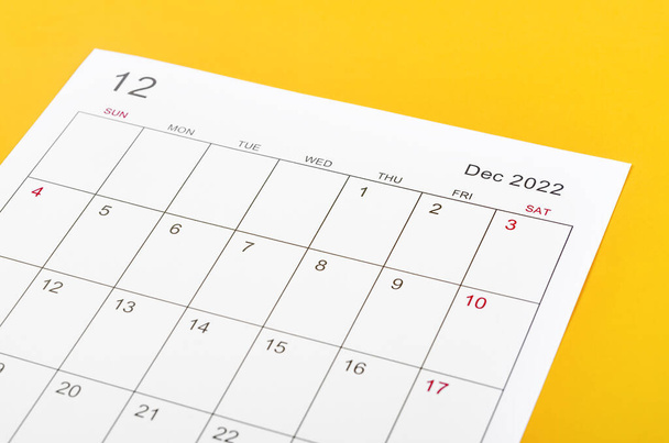 Close up December 2022 calendar sheet on yellow background. - Fotografie, Obrázek