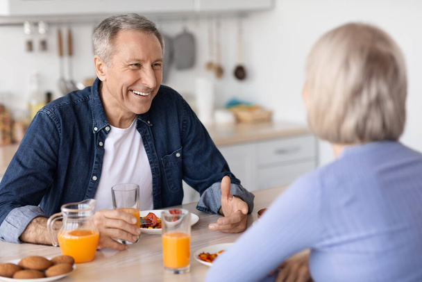 Веселий старший чоловік снідає зі своєю дружиною
 - Фото, зображення