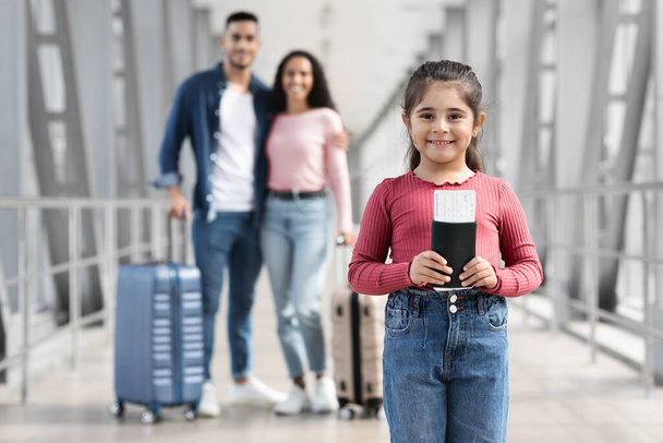 Aranyos kislány pózol a repülőtéren, miközben utazik a szülőkkel - Fotó, kép