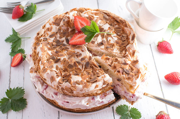 Strawberry cream cake with meringue and almond topping on white table background from above with copy space. Traditional german "Jensen Torte" - Valokuva, kuva