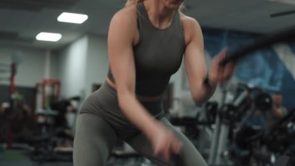 Jonge vrouw die traint met touwen aan een sportschool. Opgenomen met RED helium camera in 8K.  - Video
