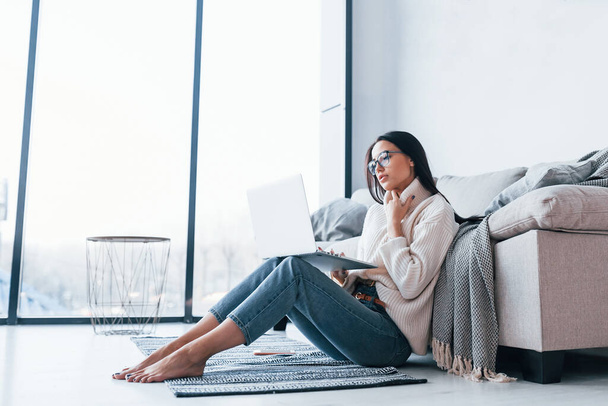 Young beautiful woman in glasses sitting at home alone with laptop. - Foto, Imagem