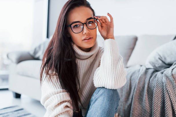 Young beautiful woman in casual clothes and in glasses sitting at home alone. - Foto, Bild