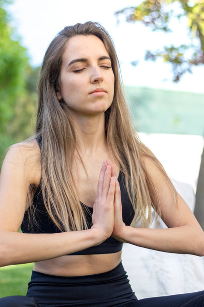 Retrato de una joven rubia hermosa practicando yoga en el jardín en un estilo de vida saludable y equilibrado - Foto, imagen