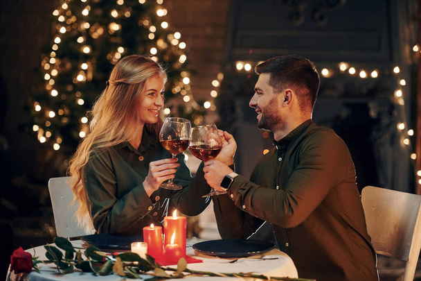 Drinks wine. Young lovely couple have romantic dinner indoors together. - Photo, Image