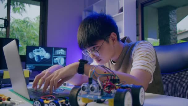 Asian teenager doing Arduino robot homework project in house, technology of robotics programing and kids education concept. - Video, Çekim