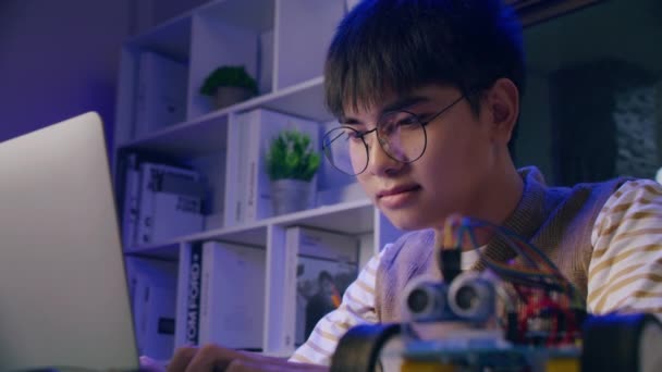 Азіатський підліток, який займається домашнім завданням робота Ардуіно, технологією програмування робототехніки та дитячою освітою.. - Кадри, відео