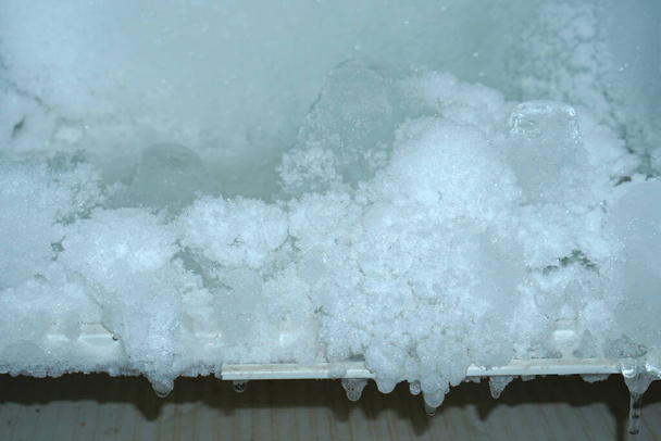 Het ijs kleeft aan elkaar in het koelvak. - Foto, afbeelding