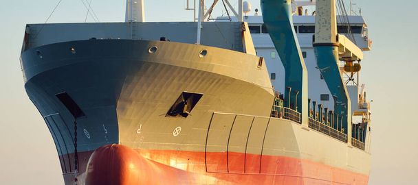 Velká jeřábová loď (všeobecný náklad, délka 146 metrů) plující na otevřeném moři při západu slunce. Zlaté slunce. Nákladní doprava, logistika, globální komunikace, ekonomika, průmysl, celosvětová doprava - Fotografie, Obrázek