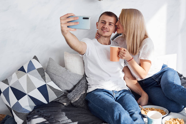 Man holding phone and making selfie of himself and his girlfriend. - Φωτογραφία, εικόνα