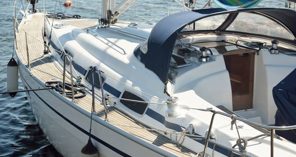 Modern charter yacht moored to a pier in marina. Top down view of the wooden teak deck, mast and sails. Mediterranean sea. Private vessel for rent, cruise, recreation, leisure activity, sport, regatta - Photo, Image