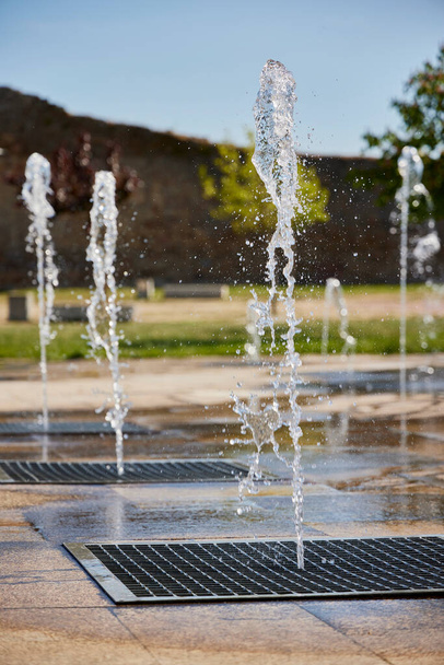 Water game. Fountain with several vertical water jets - Foto, afbeelding