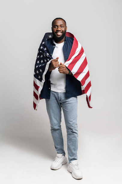 Portrait of positive muscular afro american guy covered with usa flag - Foto, imagen