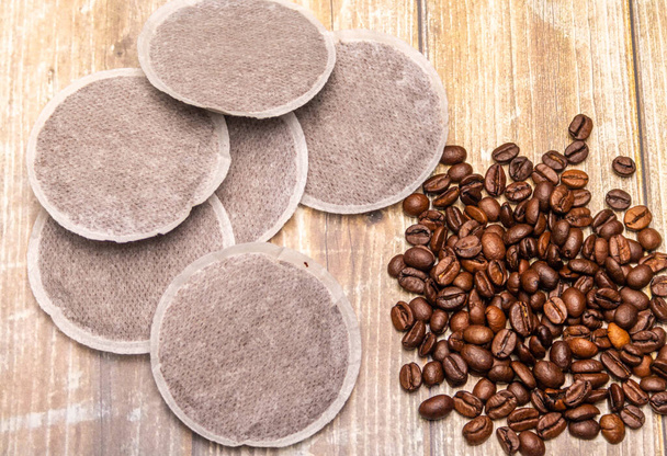 Top view of coffee pads and coffee beans on a rustic wooden surface as an example of various coffee raw products. Flat Lay composition - Valokuva, kuva