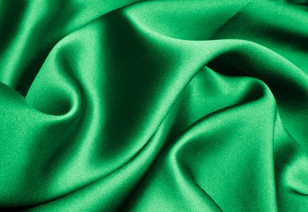 πράσινο μετάξι σχηματίζοντας κομψό κύματα με σκιές και chiaroscuro, φόντο από υφαντική ύλη - Φωτογραφία, εικόνα