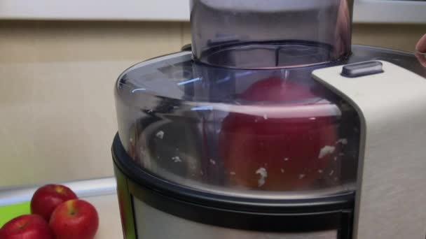 Making fresh apple juice on juicer. Slow motion, close up. - Záběry, video