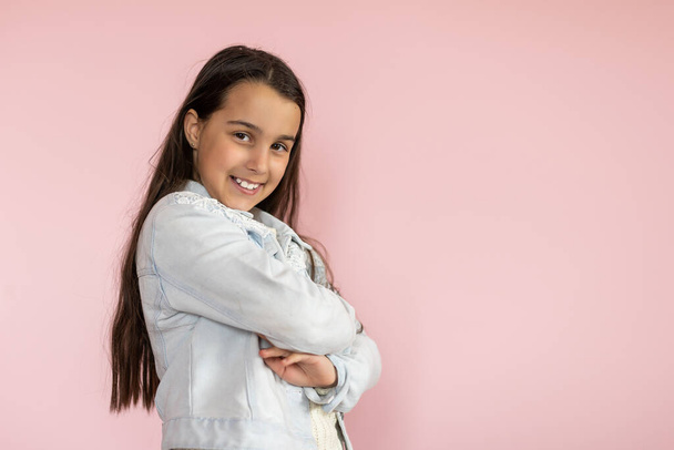 Portrait of pretty kid standing looking wearing trousers isolated over pink background - Photo, Image