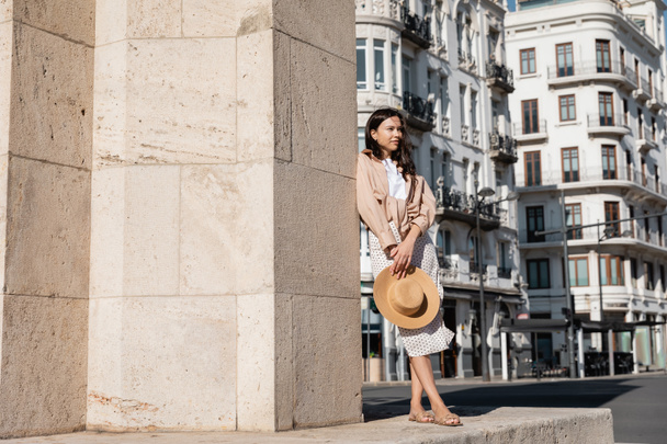 full length view of woman in trendy clothes standing near wall on street - Foto, immagini