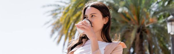 low angle view of brunette woman drinking coffee outdoors, banner - Fotografie, Obrázek