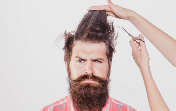 Haircut. Barber Shop procedures. Hairdresser concept. Woman cuts hair with scissors. Man with long beard, mustache and stylish hair. - Foto, imagen