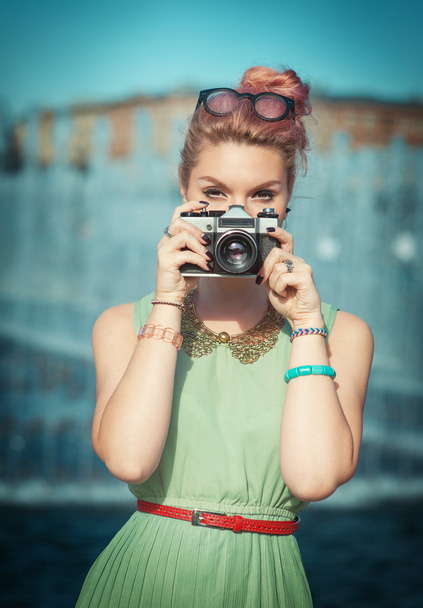 Hermosa chica en ropa vintage haciendo foto con cámara retro
 - Foto, imagen